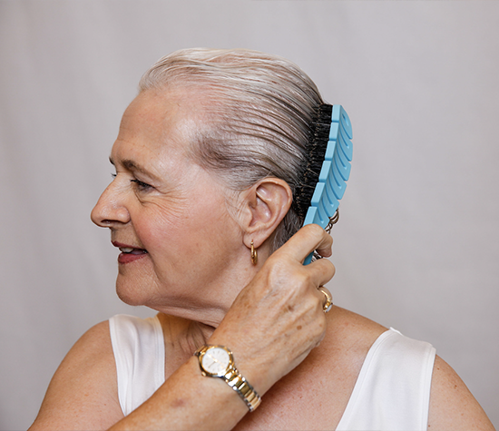 Older woman with gray hair using the Flex Brush