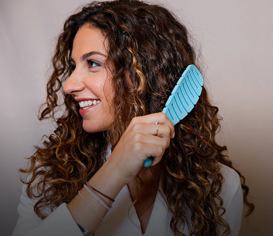Curly Haired woman using the Flex Brush