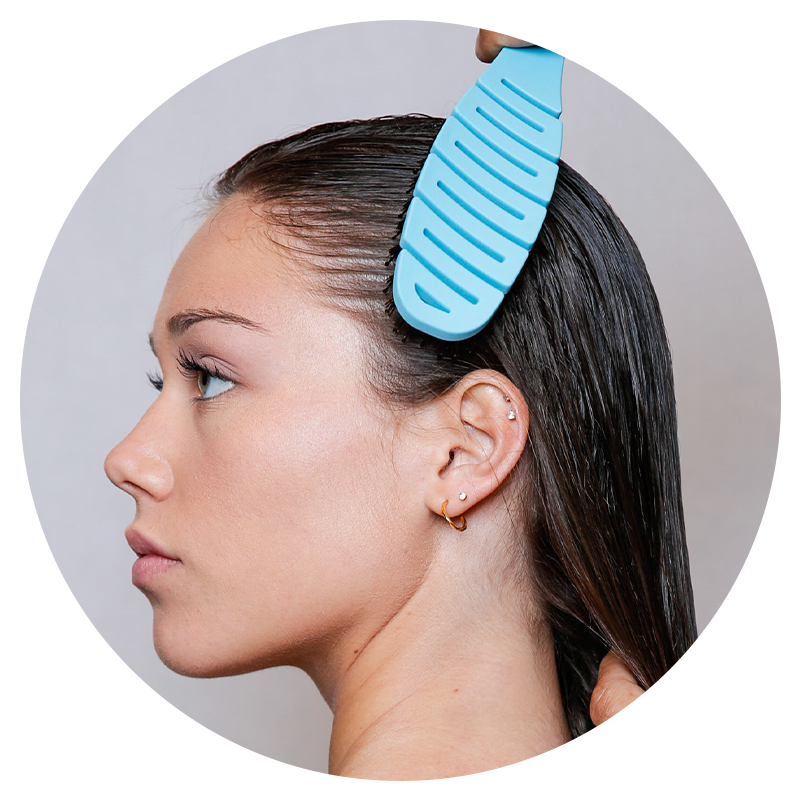 A woman using the Flex Brush to brush her wet hair